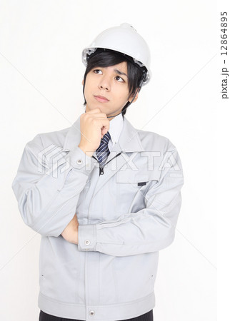 困っている作業服を着た男性 12864895