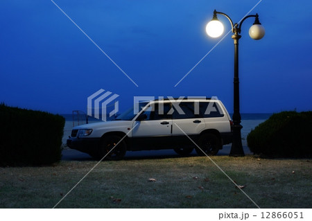 White Car on Coast Road under Lantern in Summer Night. 12866051