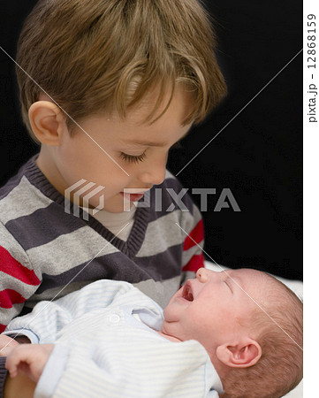 Curious Boy holding his little brother Curious Boy holding his little brother 12868159