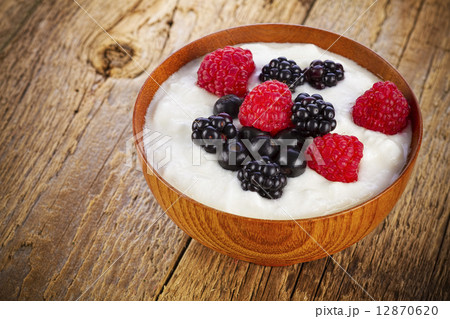 yogurt with forest berries in wooden bowl 12870620