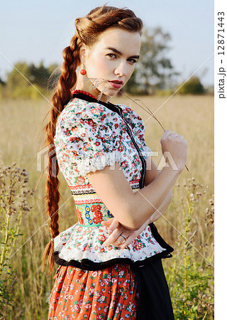 Young peasant woman, dressed in Hungarian national costume, posing over nature background 12871443