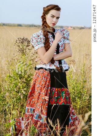 Young peasant woman, dressed in Hungarian national costume, posing over nature background 12871447