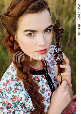 Young peasant woman, dressed in Hungarian national costume, posing over nature background 12871452