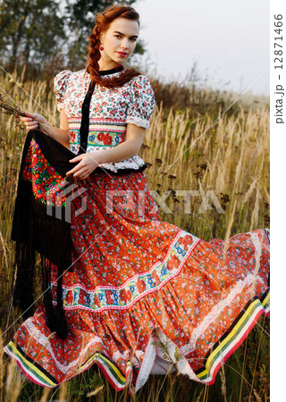 Young peasant woman, dressed in Hungarian national costume, posing over nature background 12871466