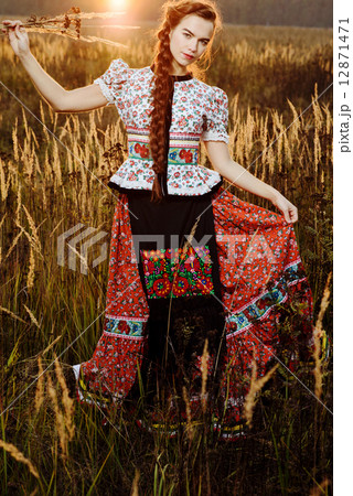 Young peasant woman, dressed in Hungarian national costume, posing over nature background Young peasant woman, dressed in Hungarian national costume, posing over nature background 12871471