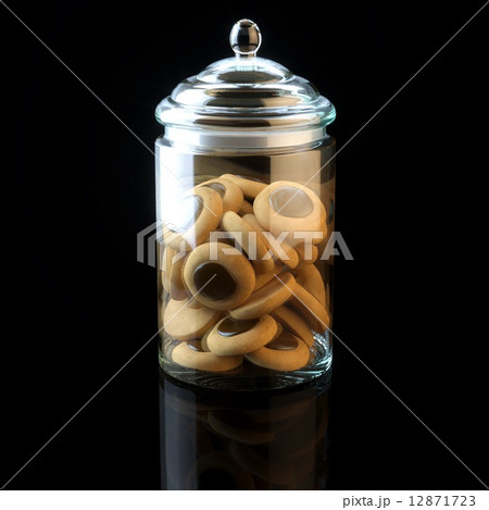 Glass jar full of chocolate cookies on black background 12871723