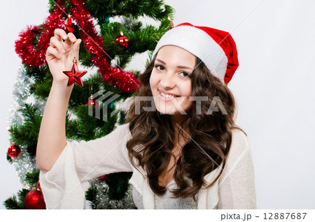 Beautiful girl in santa hat near a christmas tree with with Christmas toy 12887687