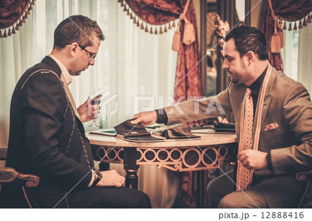 Tailor and client choosing cloth and buttons for custom made suit Tailor and client choosing cloth and buttons for custom made suit 12888416