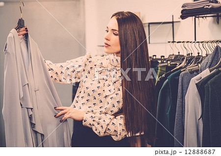 Young woman choosing clothes on a rack in a showroom Young woman choosing clothes on a rack in a showroom 12888687