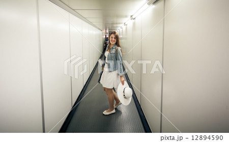 woman with bags walking at boarding gate at airport woman with bags walking at boarding gate at airport 12894590