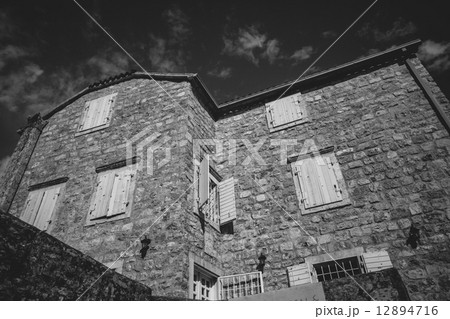 Monochrome photo of old stone house at sunny day 12894716