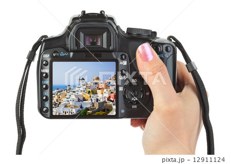 Camera in hand and Santorini (Greece) view Camera in hand and Santorini (Greece) view 12911124
