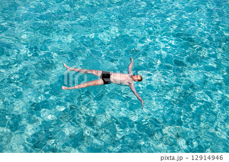 Teenager has a rest on turquoise transparent water of ocean.. Teenager has a rest on turquoise transparent water of ocean.. 12914946