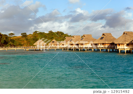 Typical Polynesian landscape - seacoast with palm trees and small houses on water 12915492