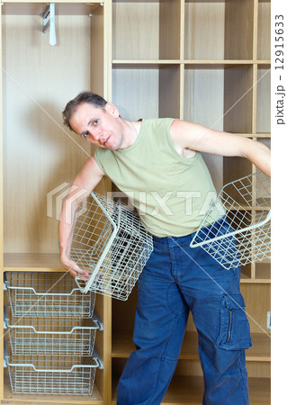 The man establishes baskets in a new wardrobe 12915633