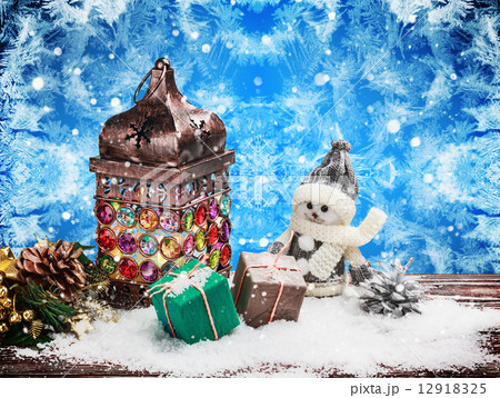 Burning lantern and Christmas decorations in the snow Burning lantern and Christmas decorations in the snow 12918325
