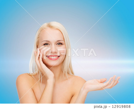 smiling woman holding imaginary lotion jar 12919808