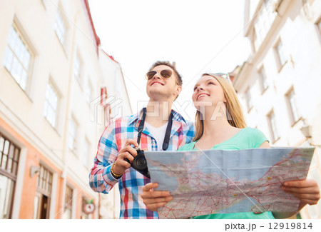 smiling couple with map and photo camera in city smiling couple with map and photo camera in city 12919814