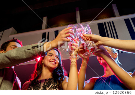 smiling friends with glasses of champagne in club 12920366