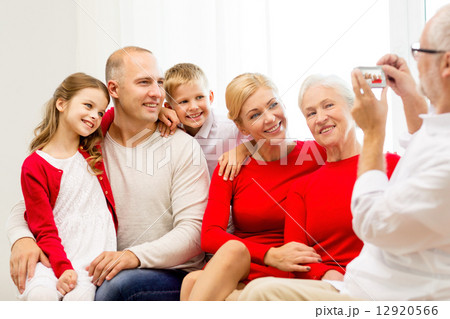 smiling family with camera at home 12920566