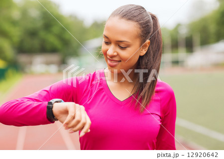 smiling woman running on track outdoors 12920642