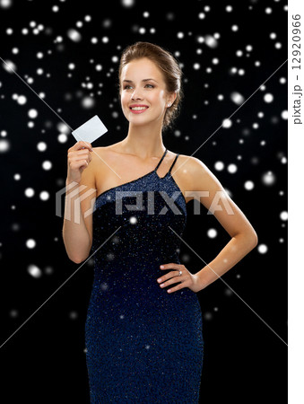 smiling woman in evening dress holding credit card 12920966