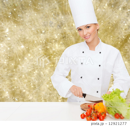 smiling female chef chopping vegetables 12921277