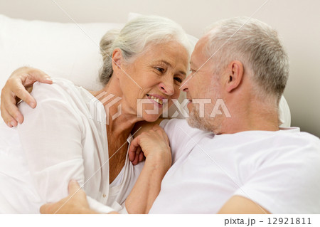 happy senior coupler lying in bad at home 12921811