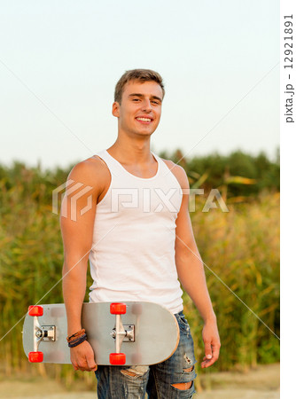 smiling teenage boy with skateboard outdoors 12921891