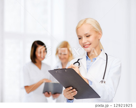 smiling female doctor with clipboard smiling female doctor with clipboard 12921925