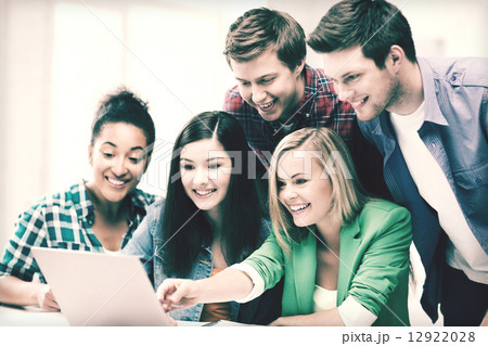 smiling students looking at laptop at school smiling students looking at laptop at school 12922028