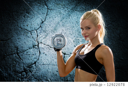 young sporty woman with heavy steel dumbbell 12922078