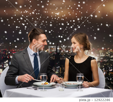 smiling couple eating main course at restaurant 12922286
