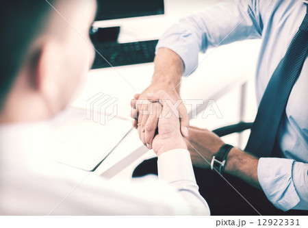 businessmen shaking hands in office 12922331
