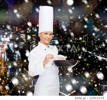 smiling female chef with pan and spoon 12922470