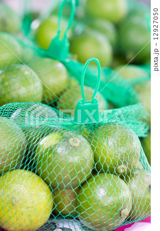 Limes with green plastic net for sell in market. 12927050