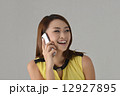 Asian lady laughing while talking on a smart phone Asian lady laughing while talking on a smart phone 12927895