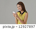 Asian lady texting with mobile phone Asian lady texting with mobile phone 12927897