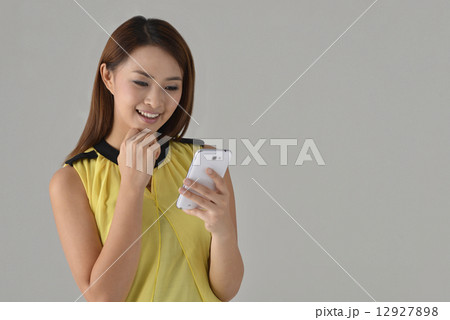 Asian lady texting with mobile phone Asian lady texting with mobile phone 12927898