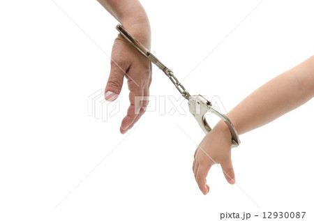 hand of mother and her child's hand with handcuff 12930087