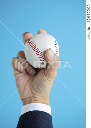 野球ボールを持つビジネスマンの手の写真素材