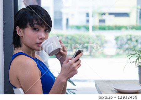 Woman glancing over while taking a sip Woman glancing over while taking a sip 12932459