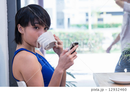 Woman glancing over while taking a sip Woman glancing over while taking a sip 12932460