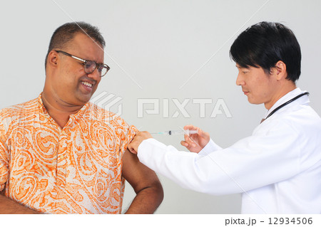 A doctor giving vaccination to a patient A doctor giving vaccination to a patient 12934506