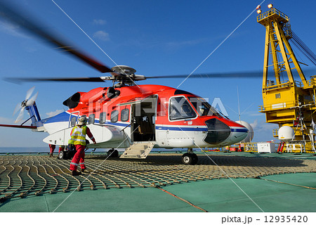 The helicopter landing officer is going to helicopter at oil rig 12935420