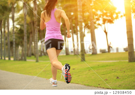 Runner athlete running at tropical park. woman fitness jogging workout wellness concept.  12938450