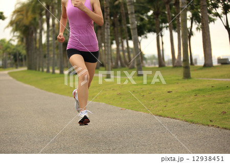 Runner athlete running at tropical park. woman fitness jogging workout wellness concept.  12938451