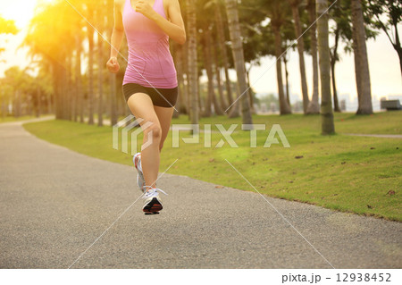 Runner athlete running at tropical park. woman fitness jogging workout wellness concept.  12938452
