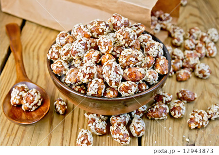 Peanuts in caramel with sesame on board 12943873