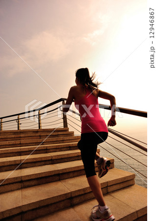 healthy lifestyle sports woman running on stone stairs seaside  12946867